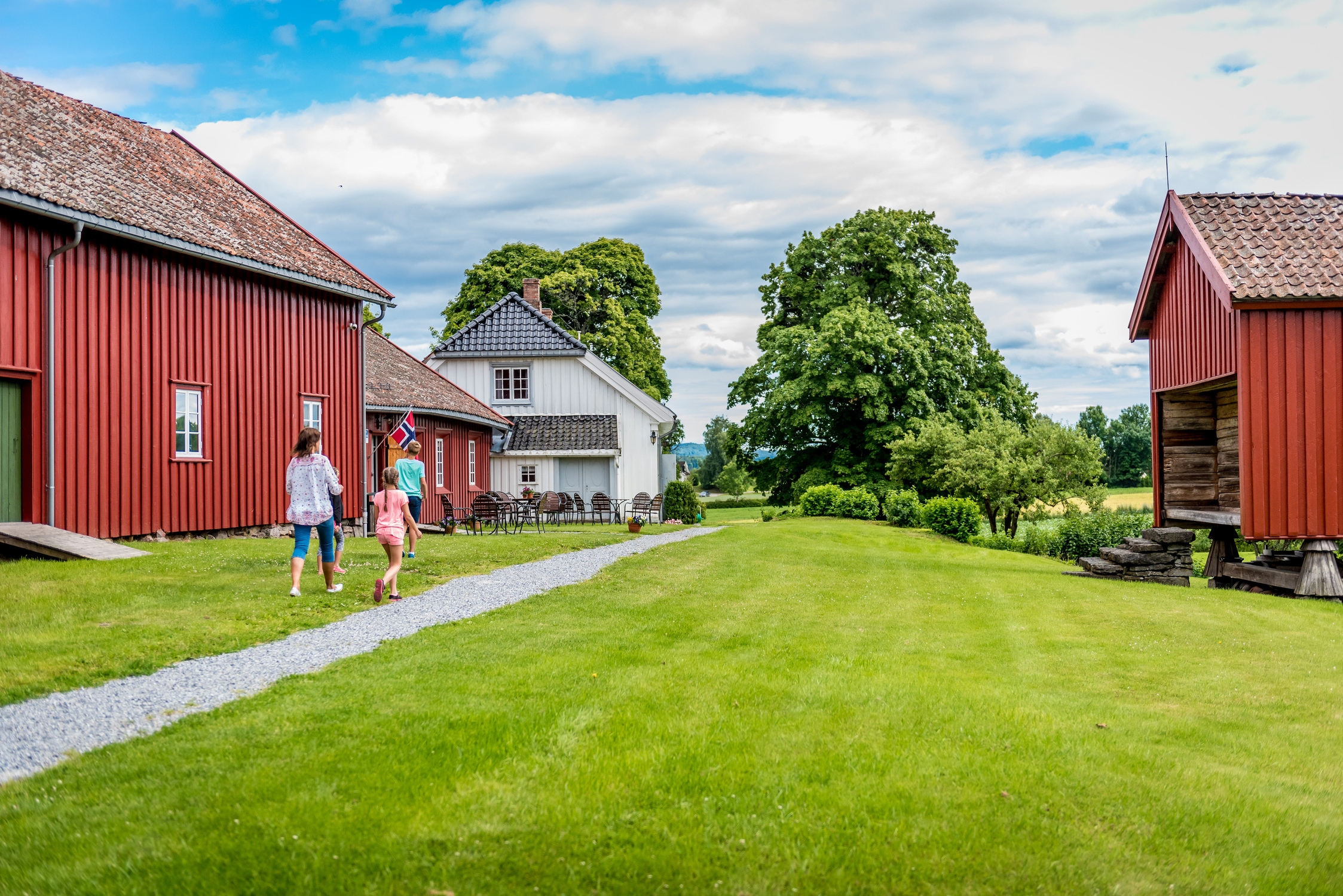M&auml;nniskor p&aring; en bondg&aring;rd med r&ouml;da hus